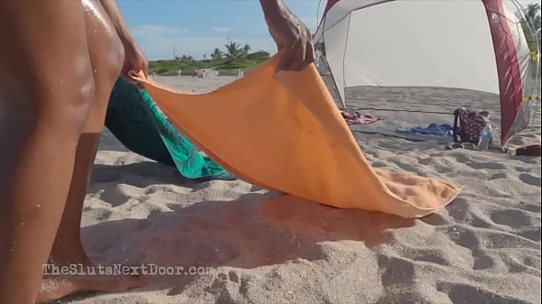 Double handjob on public beach